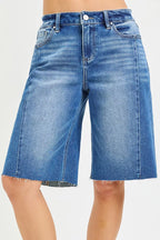 Medium-wash denim jorts with raw, frayed hem and seamed front