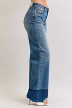 High-waist straight jeans in medium blue denim, side view with raw hem