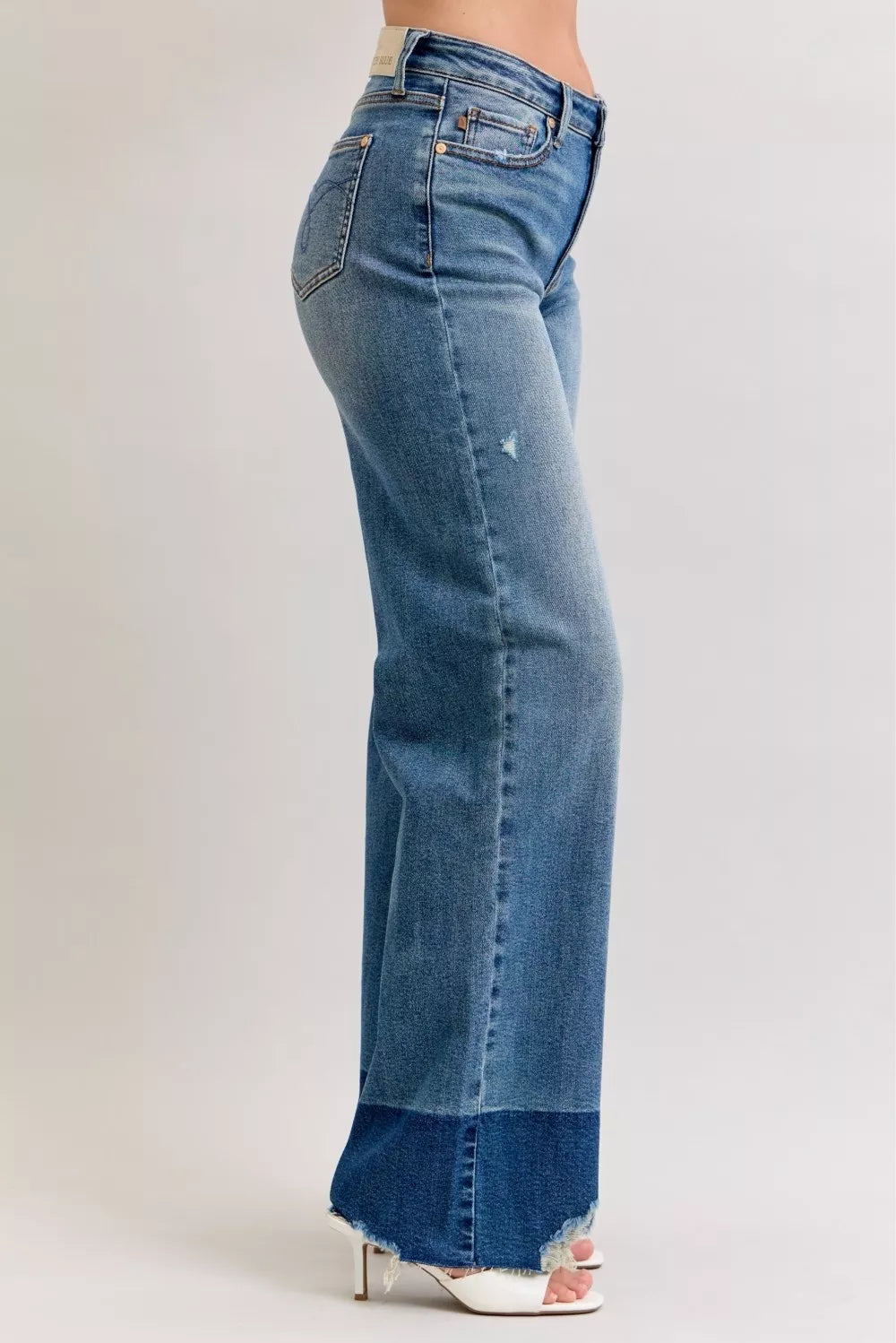 High-waist straight jeans in medium blue denim, side view with raw hem