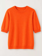 Bright orange round-neck short-sleeve sweater, flat lay with ribbed trim