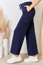 Dark blue drawstring wide-leg cargo pants with large side flap pockets