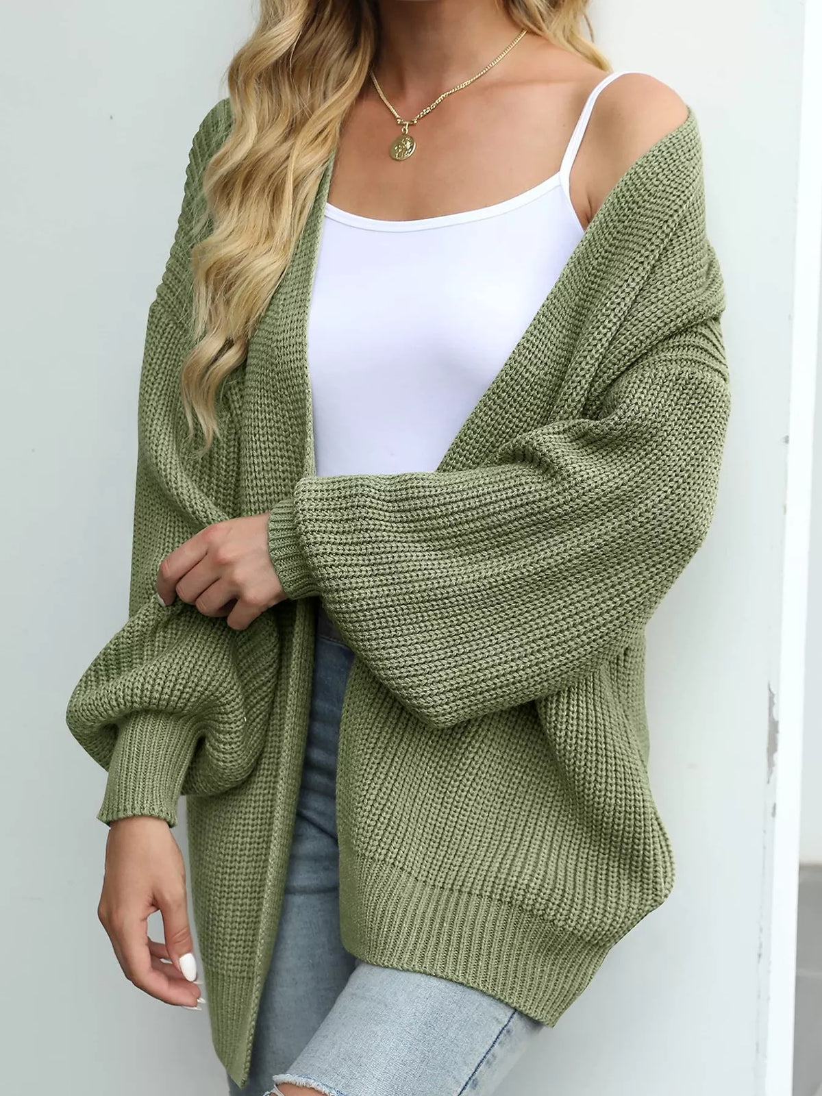 Chunky knit lantern sleeve cardigan in olive green, open front, ribbed textured knit.