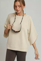 Ecru raglan sleeve round-hem top with crew neck and wide draped sleeves