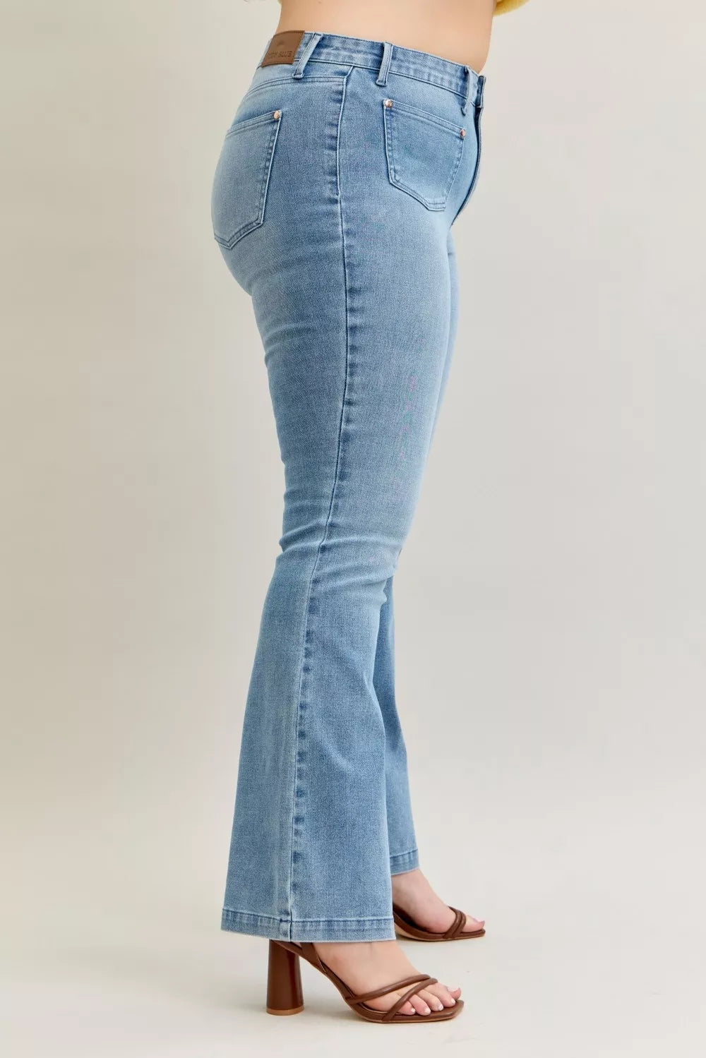 Light blue mid-rise bootcut jeans side view with visible belt loops and seam detailing
