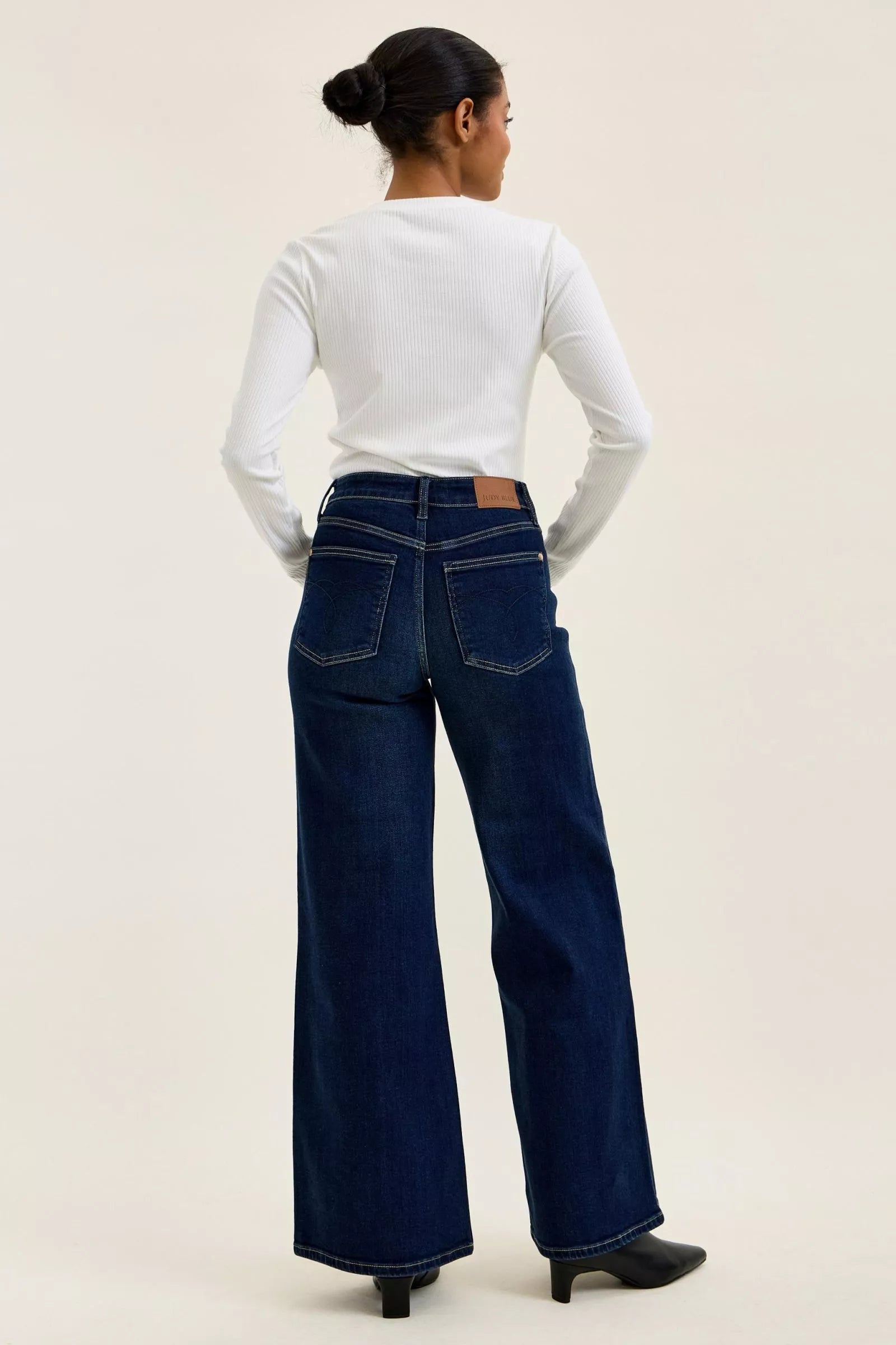 Dark wash wide-leg jeans back view with straight yoke and wide flared legs