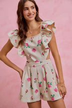 Ivory floral print denim romper with ruffled sleeves, square neckline, and belted waist