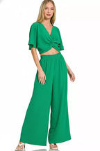 Women's green cropped wrap-style top with twist and wide-leg pants, elastic waistband