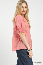 Coral pink ruffle-sleeve blouse with smocked yoke and gathered hem