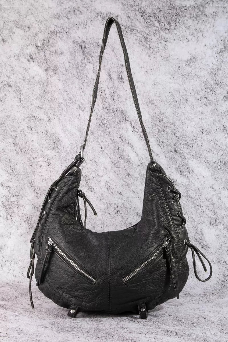 Black crescent shoulder bag with braided shoulder straps, front zip pocket, and side ties