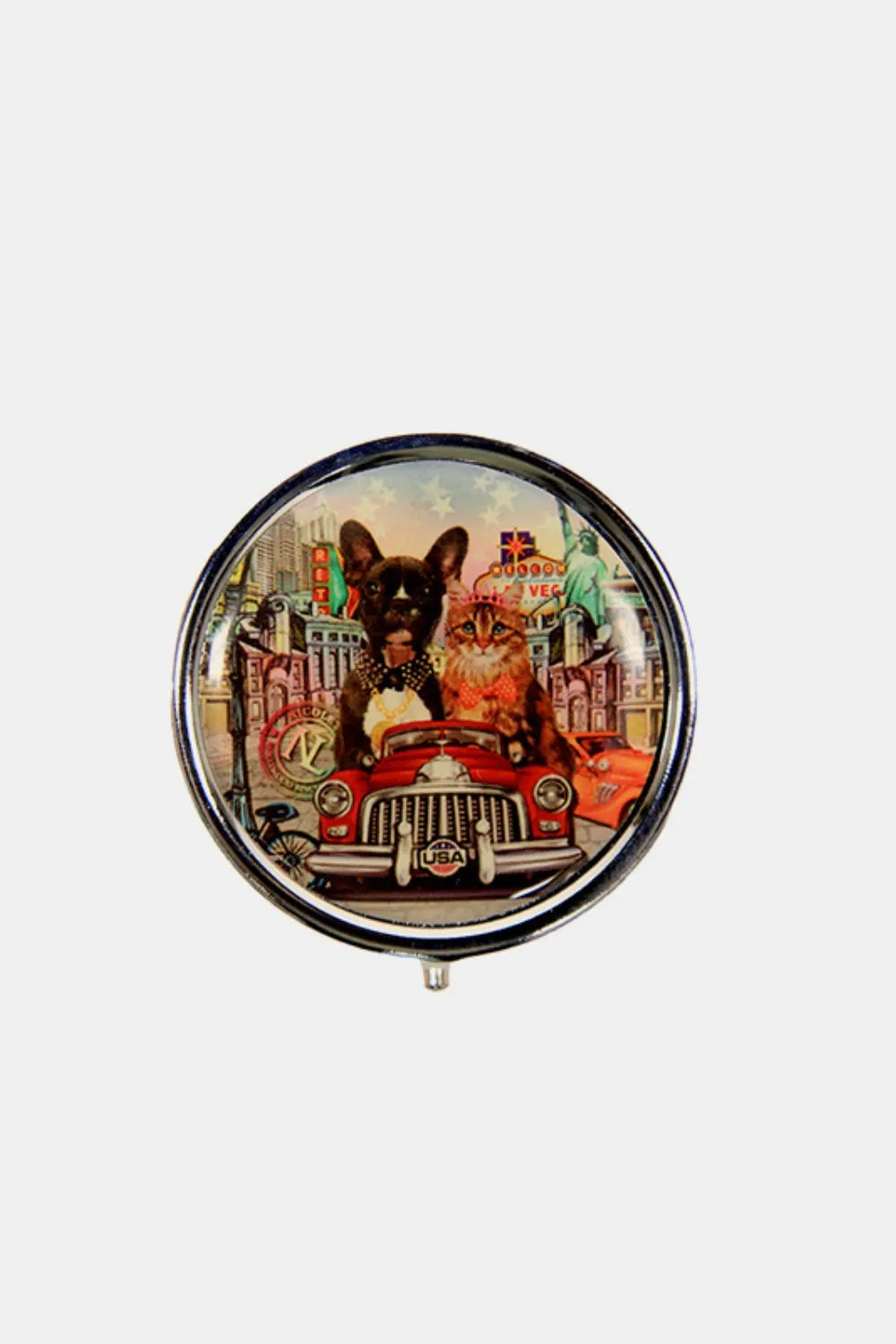 Silver-toned circular pill case with colorful city graphic on the lid