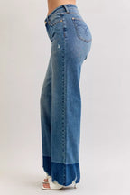 High-waist straight jeans in medium blue denim, angled side view with raw hem