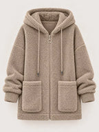 Beige fleece zip-up hoodie with drawstring hood and front patch pockets, zip front.