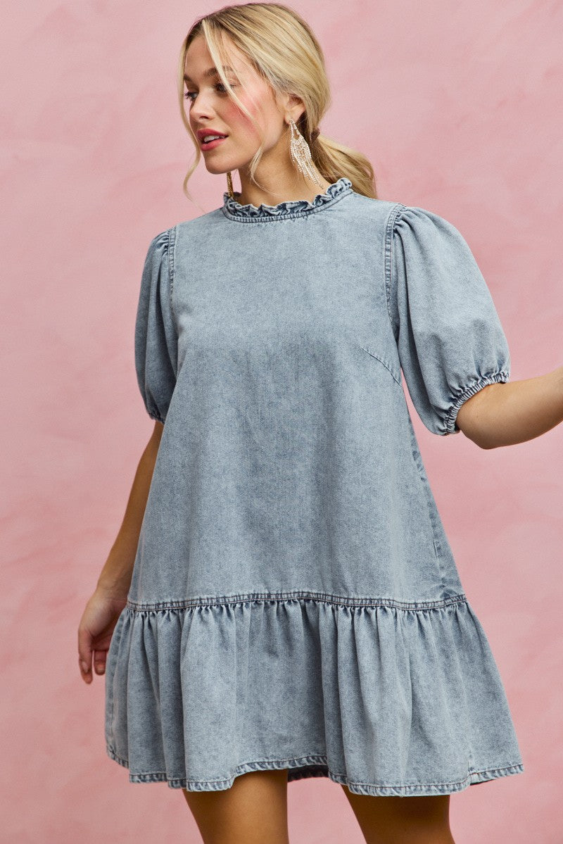 Light wash denim mini dress with ruffled neck detail and short puff sleeves, tiered skirt