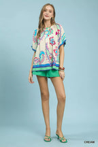 Cream border print puff sleeve blouse with green shorts, full-body view