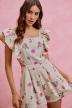 Ivory floral print denim romper with ruffled cap sleeves and pleated skirt