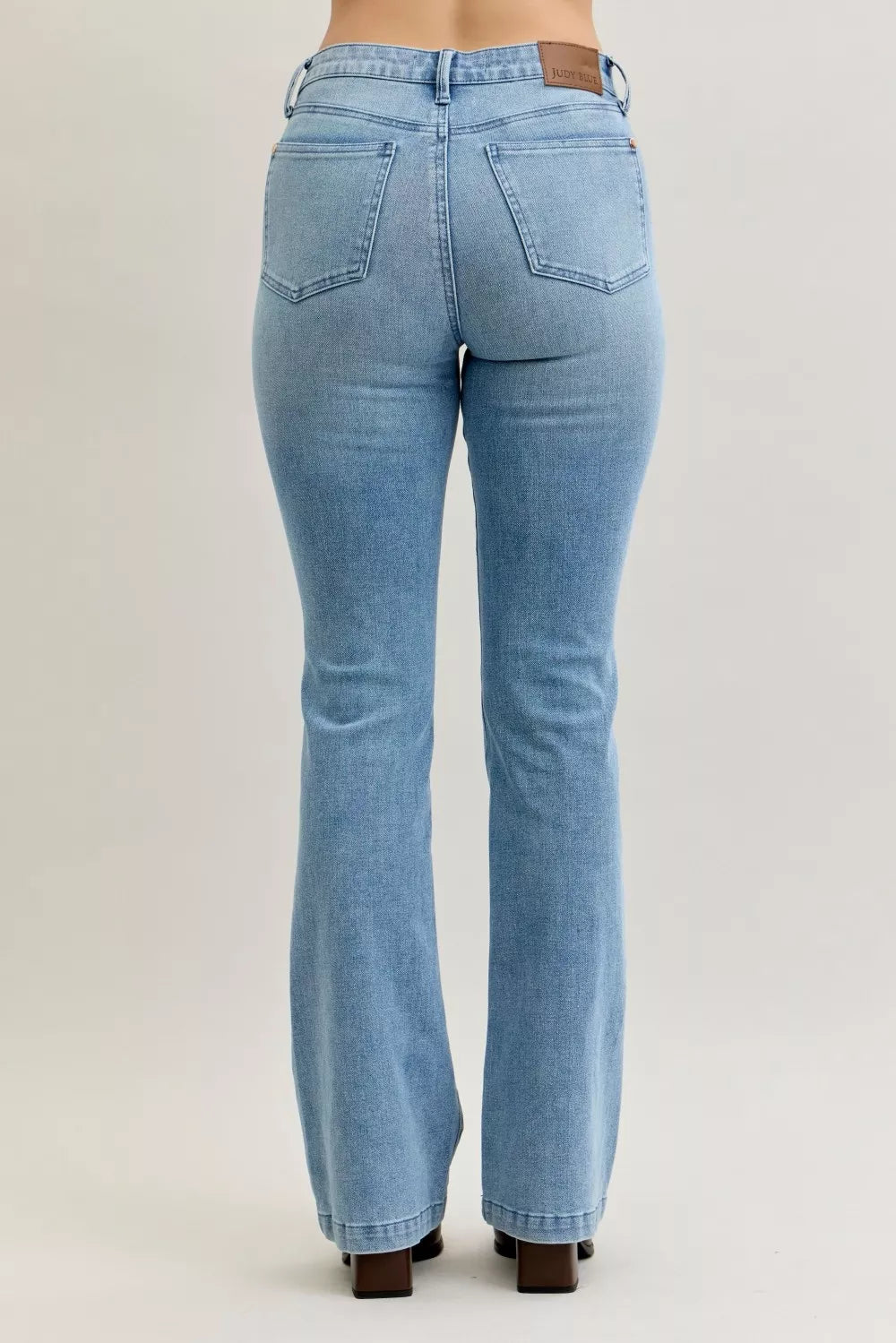 Light blue mid-rise bootcut jeans with rear patch pockets and back rise shaping