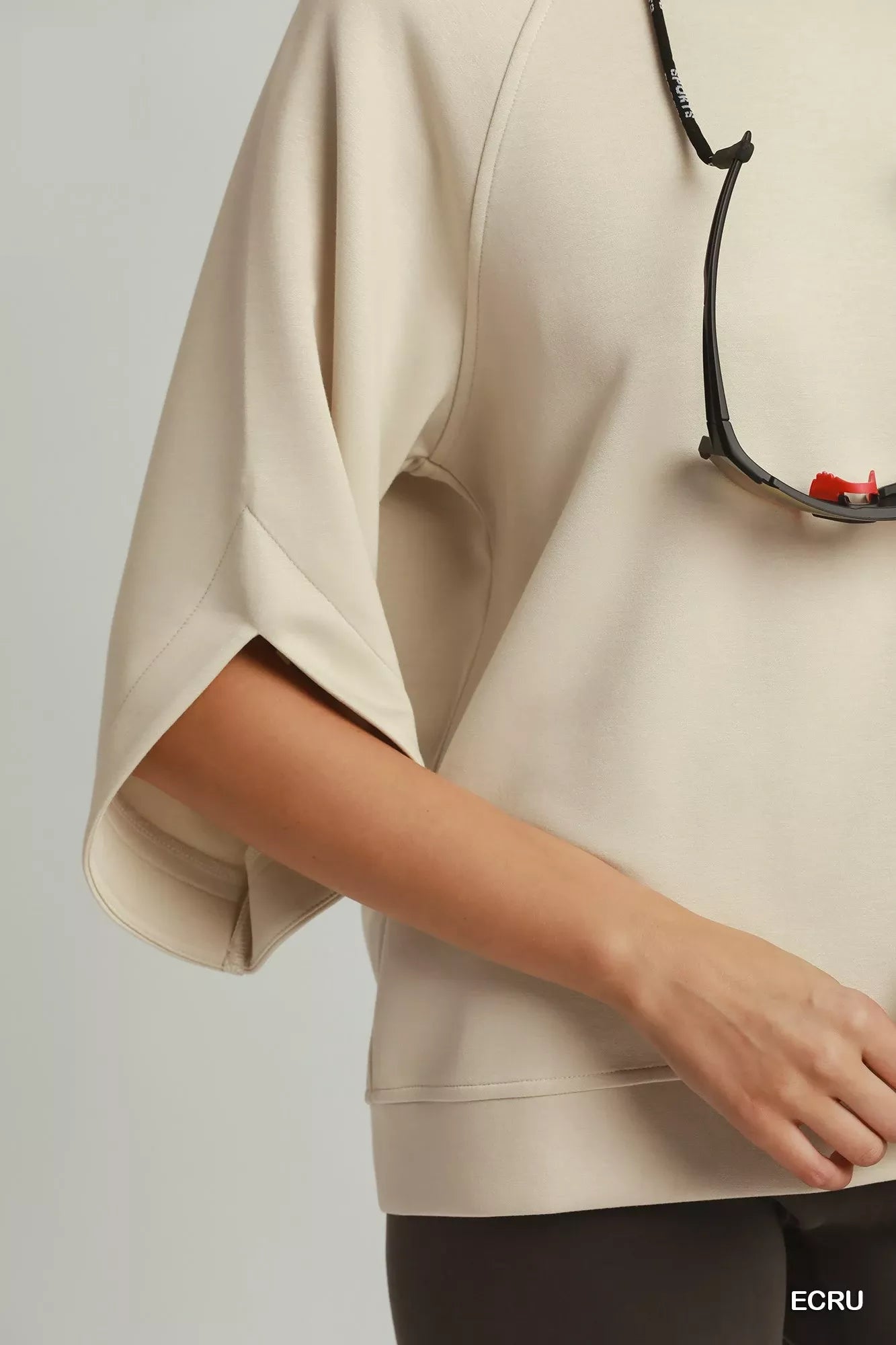Ecru raglan sleeve top close-up, curved side seam and wide sleeve opening
