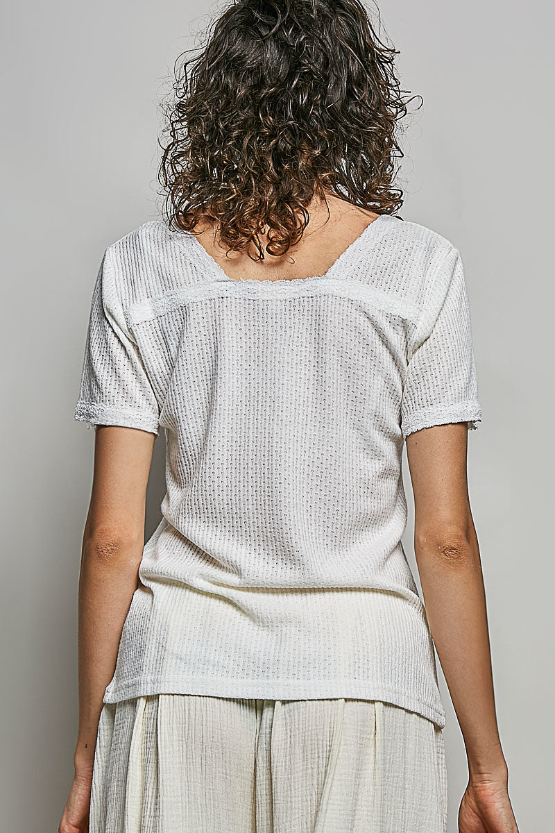 Off-white textured knit top with scoop back and short sleeves