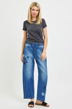 Medium-wash cropped barrel jeans with drawstring waist and star patch accents on the leg