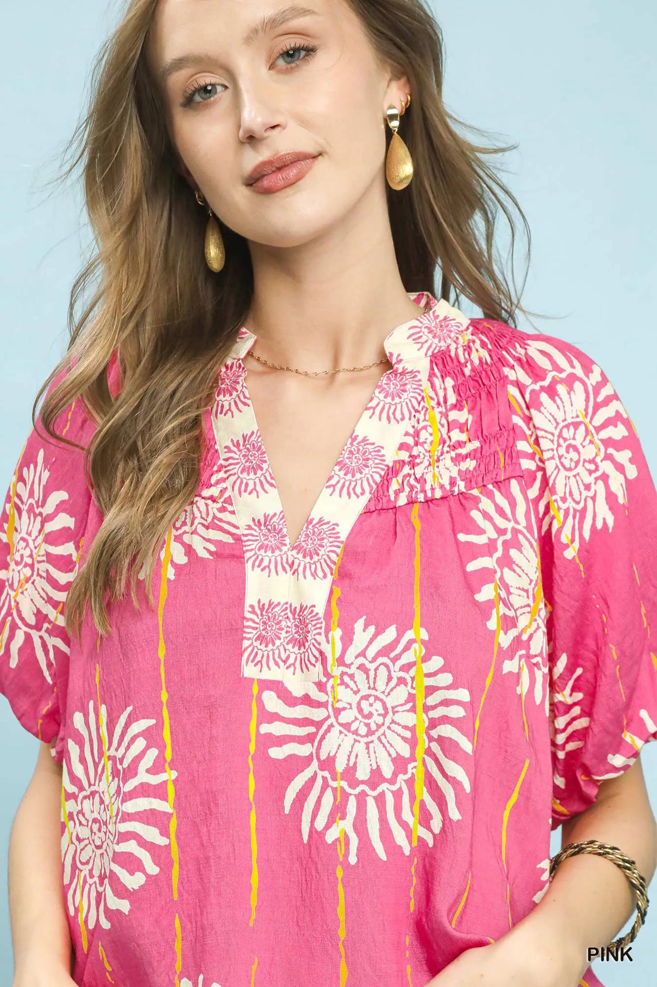 Pink floral V-neck blouse with smocked neckline and embroidered detail