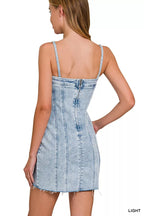 Back of light wash denim spaghetti strap dress with open exposed seams and frayed hem