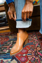 Light wash bootcut jeans with mid-rise waist and brown leather ankle boots