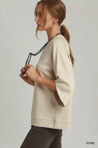 Ecru raglan sleeve round-hem top, side view with crew neckline and relaxed fit