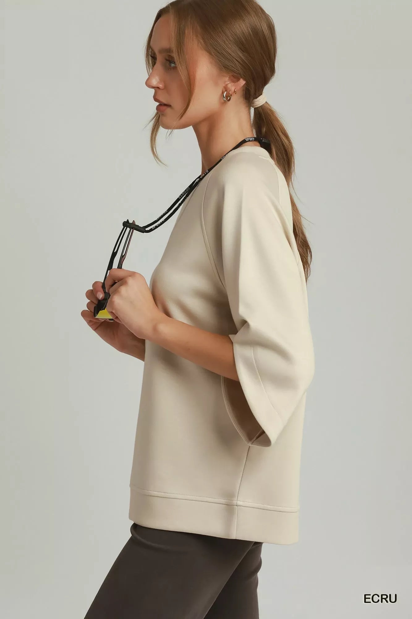 Ecru raglan sleeve round-hem top, side view with crew neckline and relaxed fit