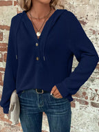 Navy waffle-knit button hoodie with hood, long sleeves, and drawstring details.