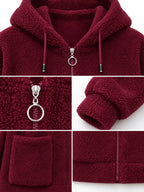 Burgundy fleece zip-up hoodie close-up: ring zipper pull, drawstring hood, patch pockets.