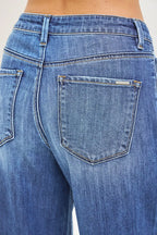 Women's medium-wash denim jeans back closeup, rear yoke and pocket detail