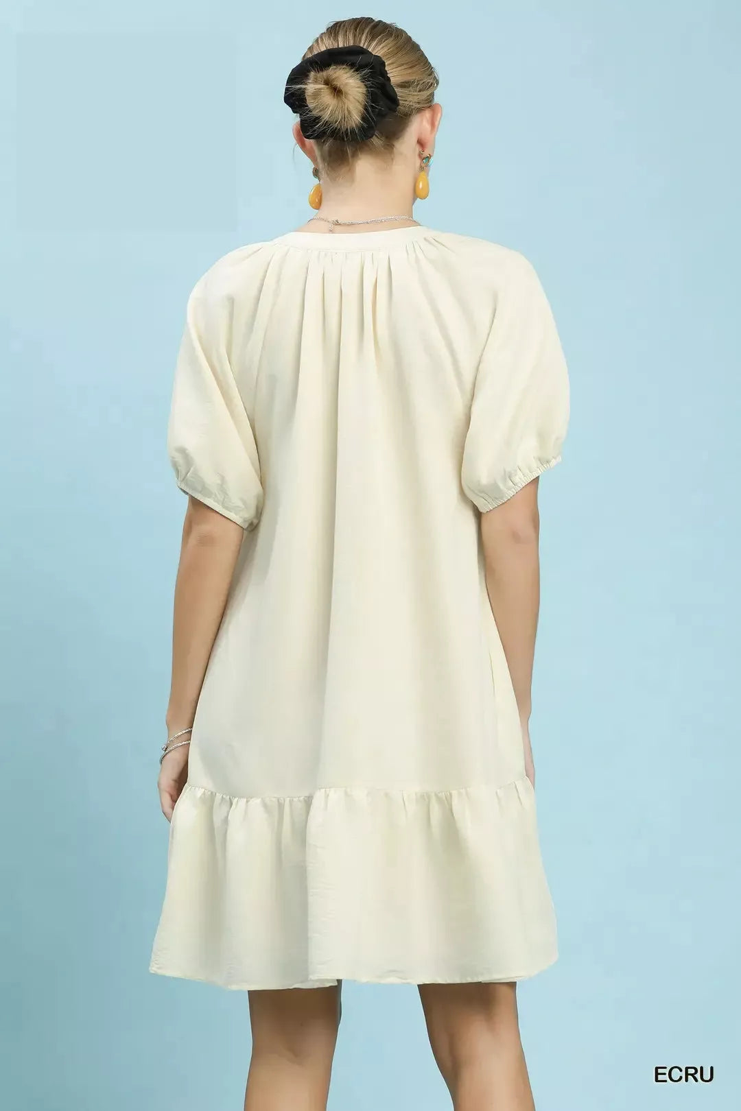 Ecru embroidered babydoll dress, back view with puff sleeves and tiered skirt