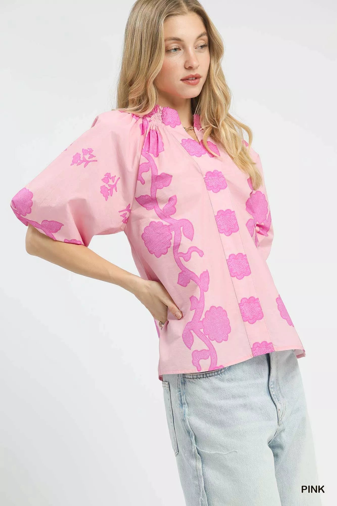 Pink floral blouse with smocked neckline and short puff sleeves, side view
