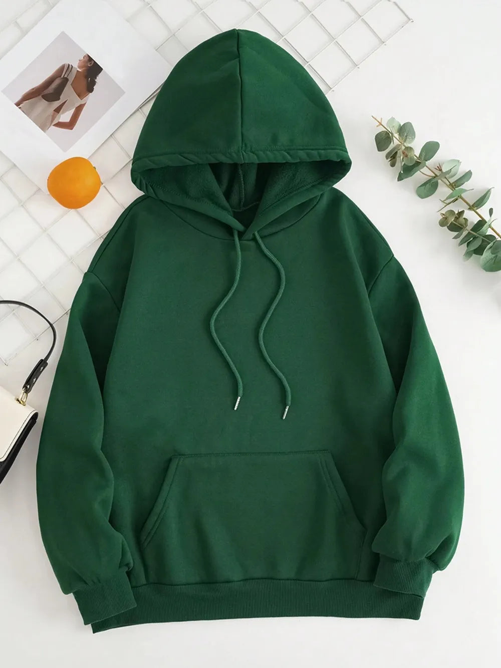 Deep green drawstring dropped-shoulder hoodie with kangaroo pocket and hood.