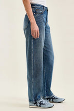 Petite wide-leg indigo wash jeans, side view with stacked hems and belt loops