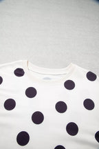 Close-up of white sweatshirt fabric with black polka dots and crew neckline