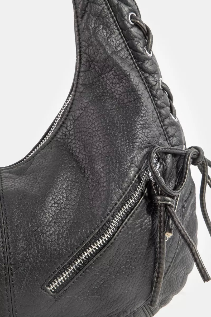 Close-up of black crescent shoulder bag with textured grain and silver-tone front zipper