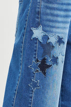Denim jeans with stitched star patches across the leg and contrast seam details