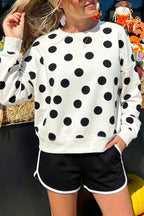 White round-neck sweatshirt with long sleeves and large black polka dots; ribbed cuffs