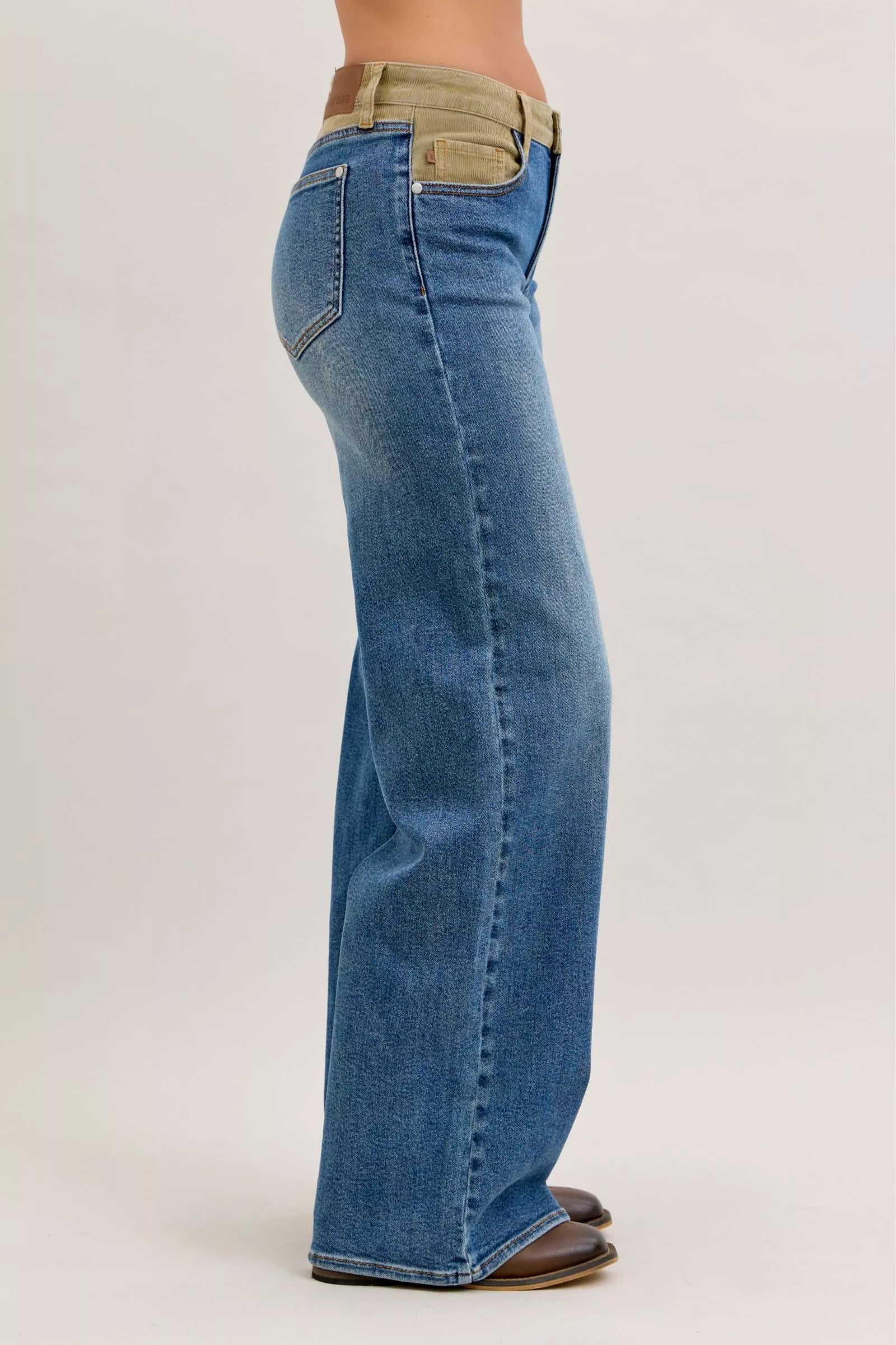 Women’s mid-rise straight jeans in blue denim with tan corduroy waistband, side view