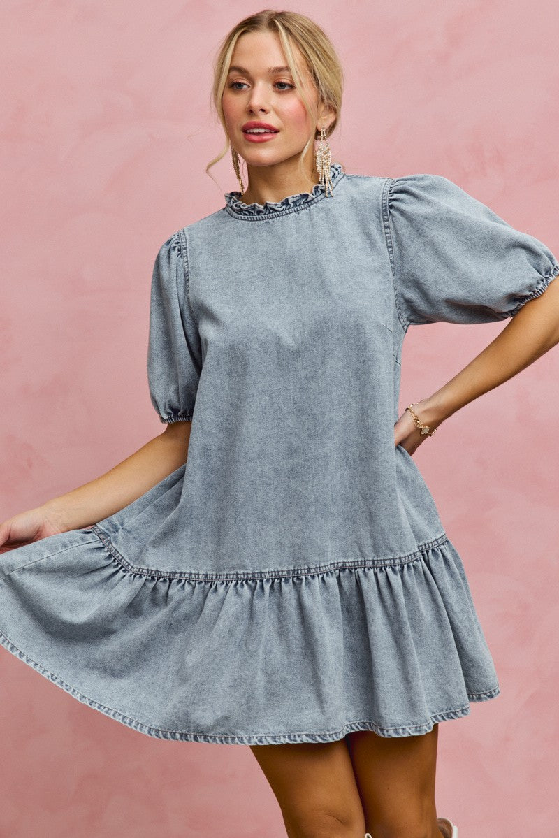 Light-wash denim mini dress with ruffled neckline and puff sleeves, layered skirt hem