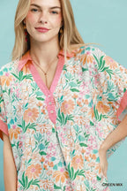 Floral v-neck blouse with pink trim, button front, and short sleeves