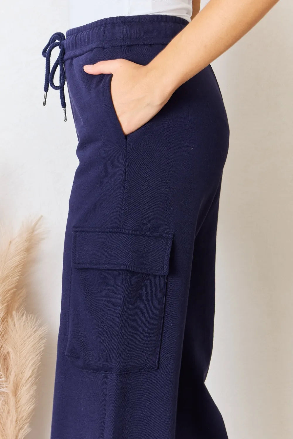 Dark blue drawstring cargo pants, textured fabric with large flap pockets