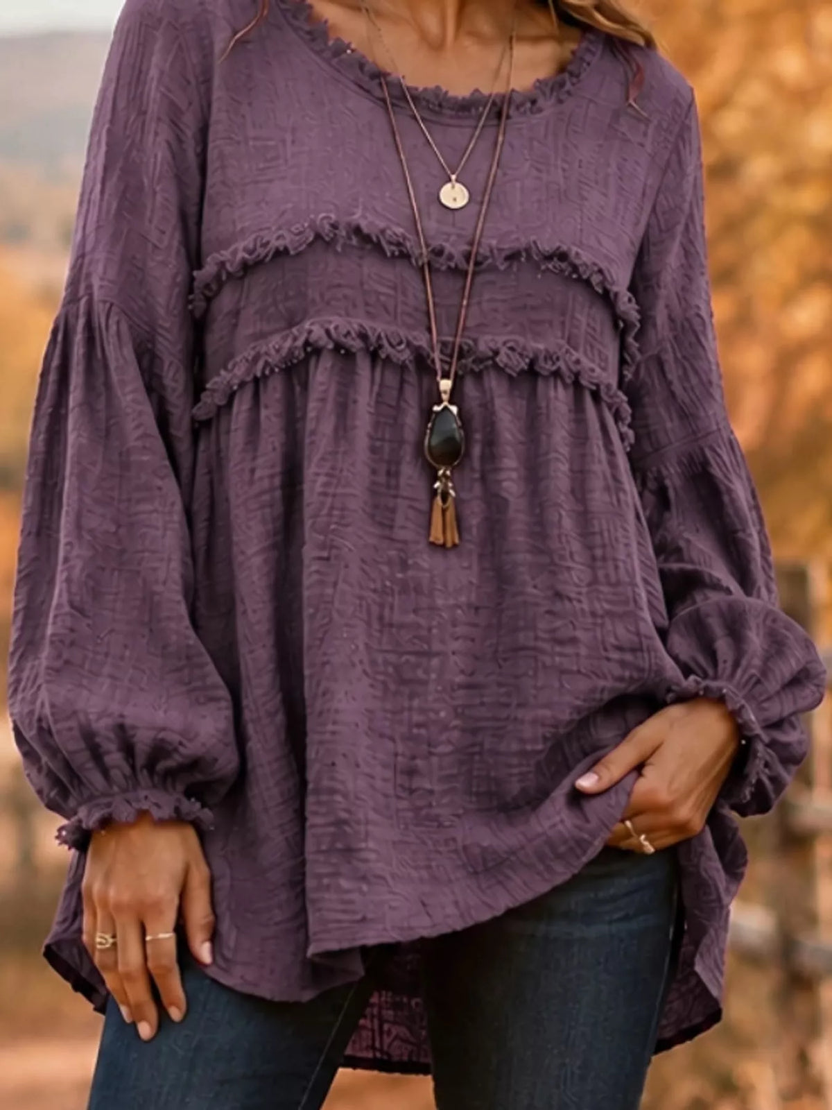 Purple frayed-trim peplum blouse with ruffle yoke and long puff sleeves, front view