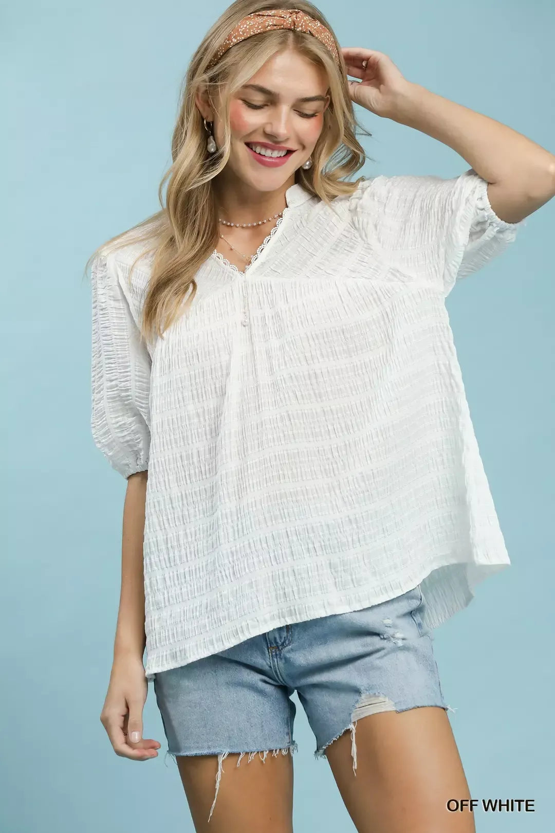 Off-white textured blouse with puff sleeves and scalloped V-neck