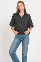 Black polo collar short-sleeve pullover sweater with relaxed shoulders and curved hem