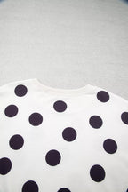 White sweatshirt close-up showing scattered black polka dots pattern