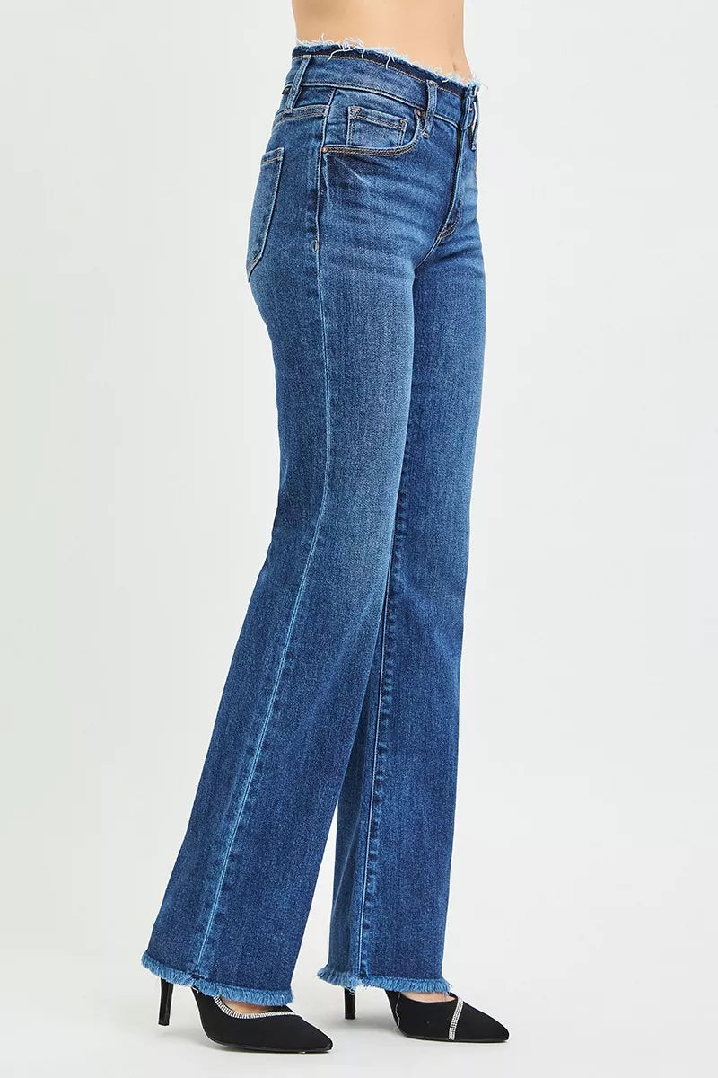 Women's dark blue bootcut jeans with back yoke, stitched pockets, and frayed hem