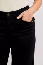 Black denim jeans waistband and front pocket close-up with button and belt loops