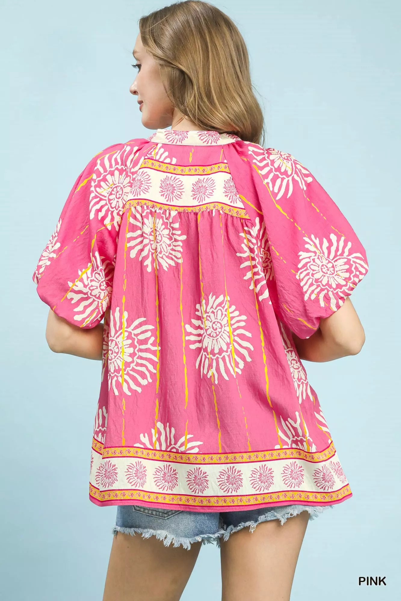 Pink floral V-neck blouse back view with gathered shoulder yoke and puff sleeves